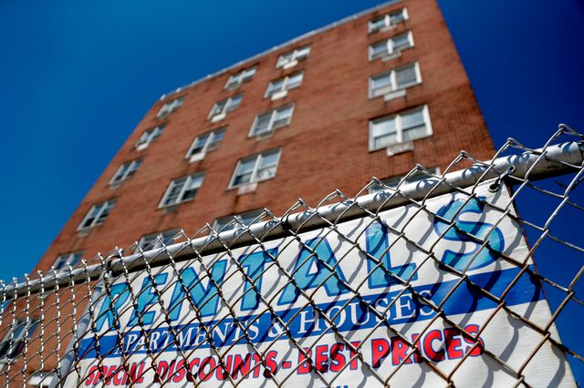 A sign hangs from the fence surrounding an apartment building in Newark, NJ.